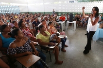 Eliane  explica a comunidade mudanças no Bolsa Família
